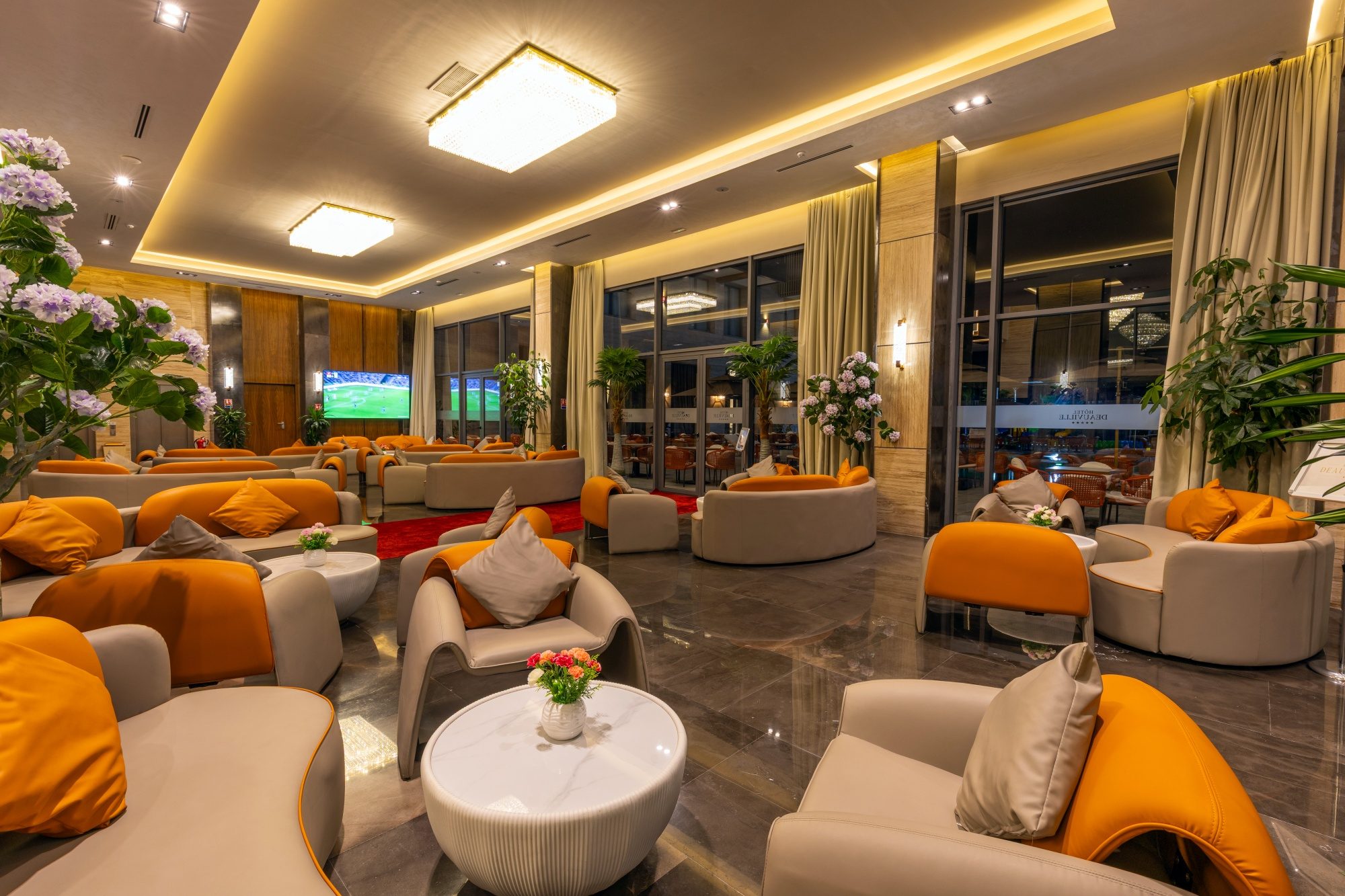 Le grand salon lounge de l'hôtel et ses canapés orange